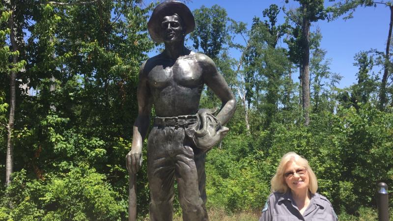 Volunteer Eleanor Anglin standing by the Civilian Conservation Corps Statue